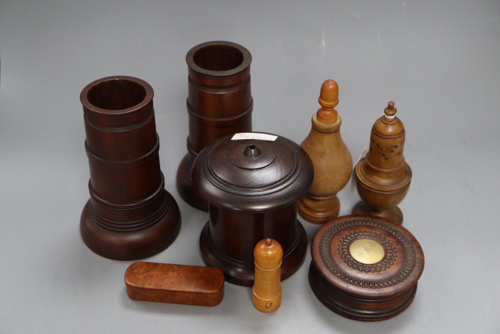 Eight items of treen including a pair of spill vases, height 16cm, a string box and a caster,